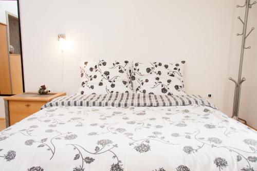 a bedroom with a bed with a white comforter at Rooms Garden Zagreb Airport in Velika Gorica