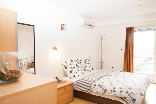 a bedroom with a bed and a large window at Rooms Garden Zagreb Airport in Velika Gorica