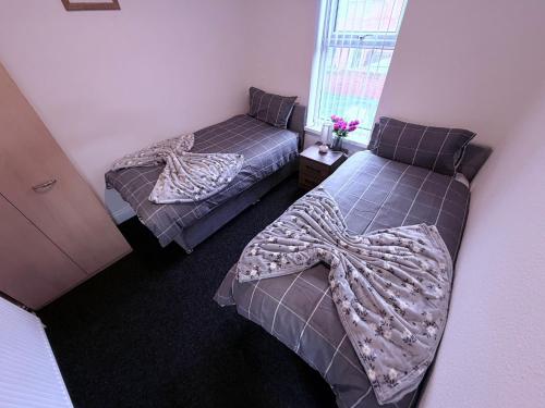 two beds in a small room with at Cozy corner - 3 Bedroom Full House - Perfect for Families, Couples And Company Contractors in Wakefield