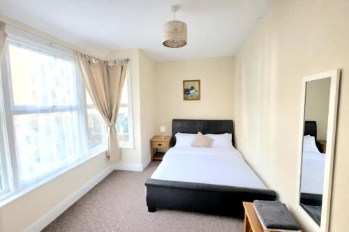 a bedroom with a bed and a large window at City Stay - free parking in Worcester