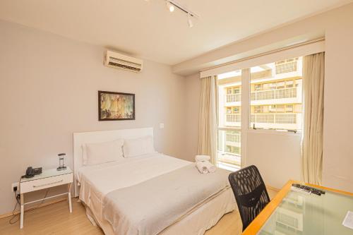 a bedroom with a bed and a desk and a window at SEQ - Sequoia Alphaville By Anora Spaces in Barueri