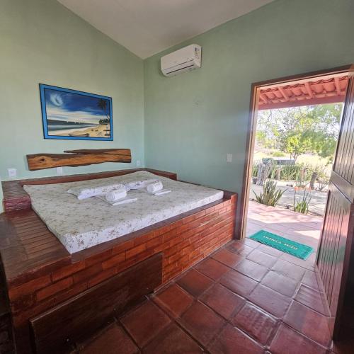 a bedroom with a bed and a sliding glass door at Pousada Mae Natureza Icapuí in Icapuí