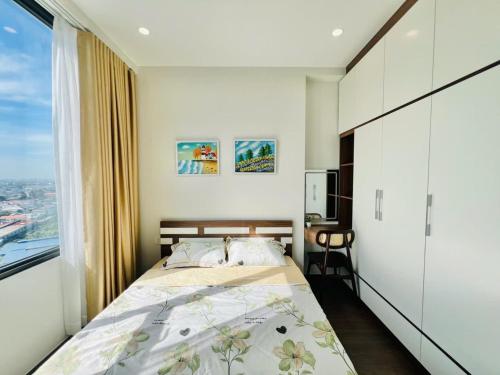 a bedroom with a bed and a large window at Youyi Home in Thuan An
