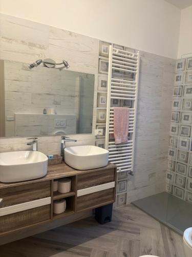 a bathroom with two sinks and a large mirror at Pella House in Airasca