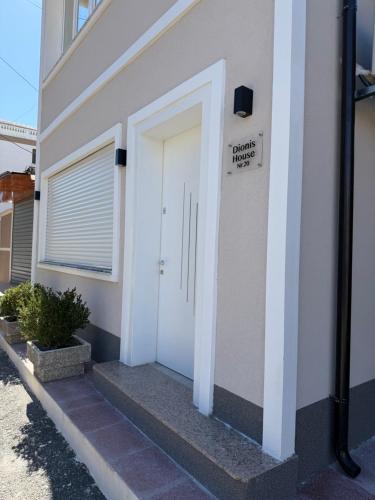 a white door on a building with a sign on it at Dionis House in Shkodër