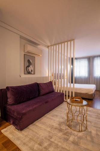 a living room with a purple couch and a bed at Terro Collection - São Vicente 86 in Braga