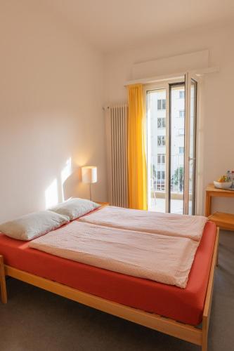 a bedroom with a large bed with a window at Locarno Youth Hostel in Locarno