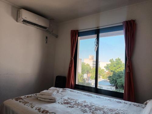 a bedroom with a bed and a large window at Mi Espacio en Gualeguaychú in Gualeguaychú