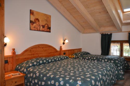 a bedroom with a bed with a blue comforter at Residence Ca' Delle Margherite in Pellizzano