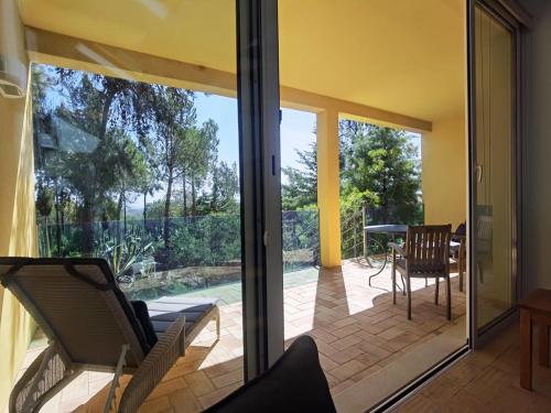 a screened in porch with chairs and a table at Quinta das Eirinhas-Jardim de Bonsai in Tavira