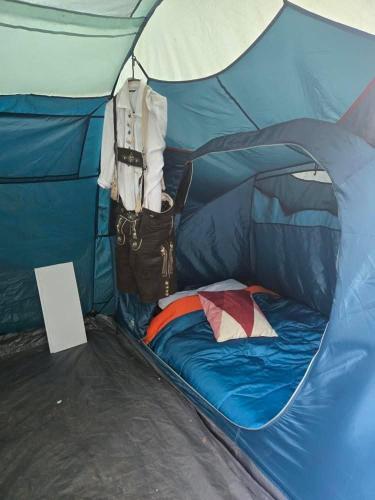 a blue tent with a bed in it at Beer Base-Camp 'BASIC PACKAGE' Oktoberfest Camping, with free welcome beer and traditional lederhosen-dirndl shop in Munich