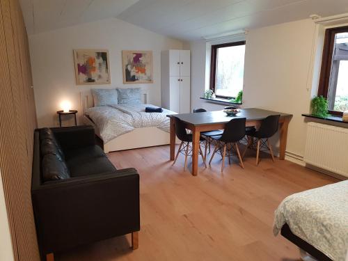 a living room with a bed and a table and chairs at Central Apartment in Billund - 500 m from LegoHouse in Billund