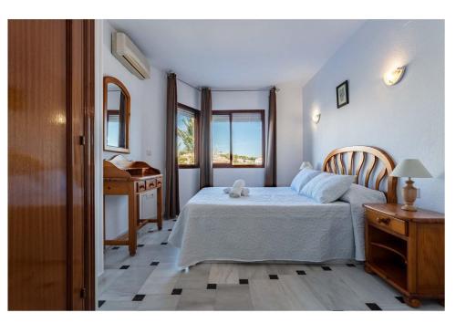 a bedroom with a bed and a table and a desk at Urb. Lubina Sol in Mijas Costa