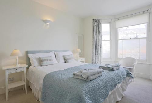 a white bedroom with a bed with towels on it at 3 Bed in Southwold oc-aacait in Southwold