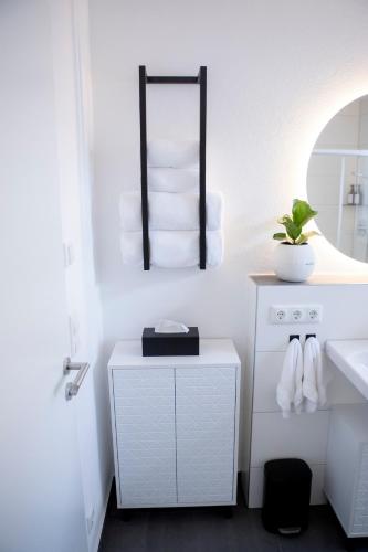 a bathroom with a sink and a pile of towels at PuraStays - studio 2 in Herzogenaurach