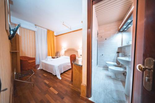 a bedroom with a bed and a bathroom with a sink at Hotel Miro' in Rapallo