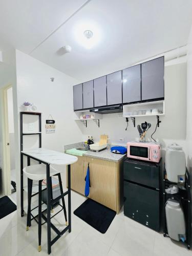 a kitchen with a counter and a table and a microwave at 2BR Staycation in Deca Banilad by XTine City Scape in Banilad
