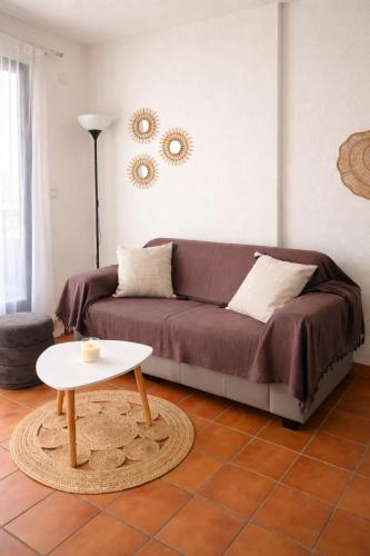 a living room with a couch and a table at Mazet avec piscine collective in Le Lavandou