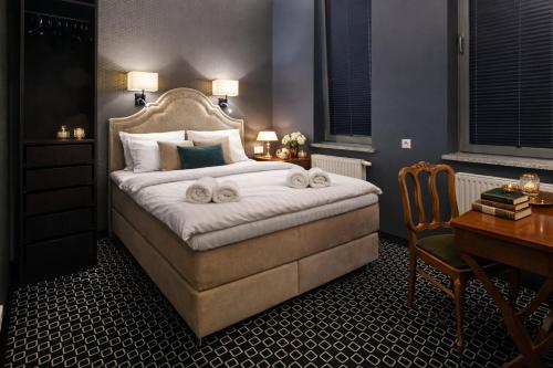 a bedroom with a large bed with a desk and a desk at Amber Suite Szczecin hotel na Starym Mieście Adults Only in Szczecin