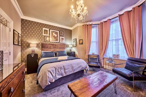 a bedroom with a bed and a chair and a chandelier at Art House in Derry Londonderry