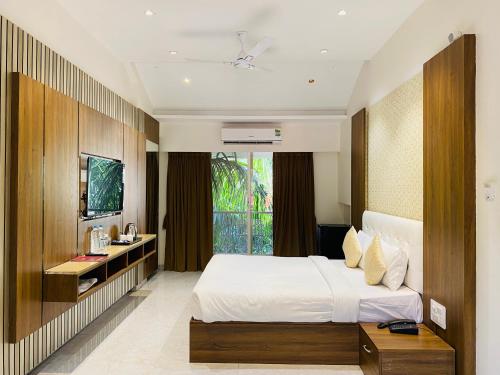 a hotel room with a bed and a television at The Grand Leela Resort in Khopoli