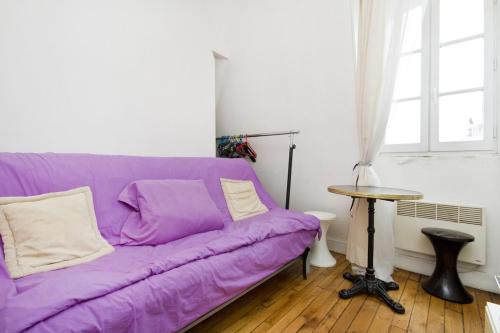 a purple couch in a living room with a table at CHAMPS ELYSEES STUDENT STUDIo in Rosières-près-Troyes