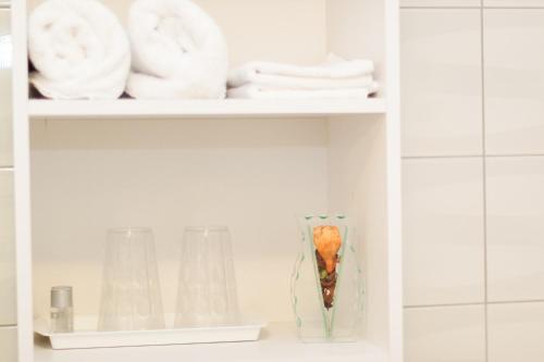 a shelf with towels and a vase in a bathroom at Rooms Garden Zagreb Airport in Velika Gorica
