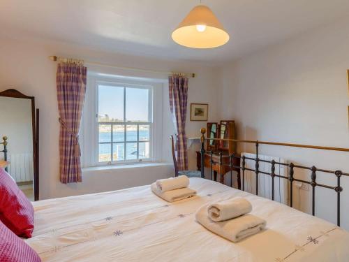 a bedroom with a large bed with two towels at 2 Bed in Polruan oc-pc033 in Fowey