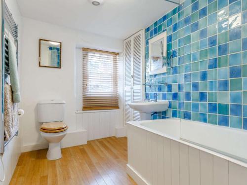 a bathroom with a tub and a toilet and a sink at 2 Bed in Polruan oc-pc033 in Fowey
