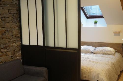a bedroom with a bed and a chair at L'atelier in Cancale