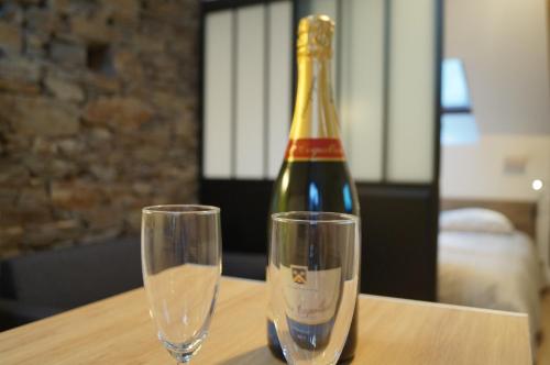 a bottle of champagne and two glasses on a table at L'atelier in Cancale