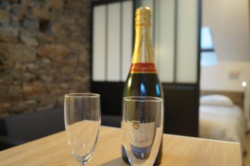 Una botella de champán y dos copas en una mesa. en L'atelier en Cancale