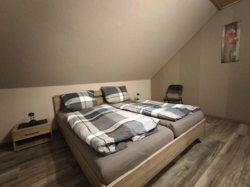 a bedroom with two beds with striped blankets and a chair at Ferienwohnung Naturblick in Schönhagen