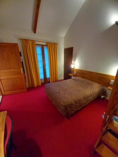a hotel room with a bed and two windows at Le Motel Saint Martin in Verneuil d'Avre et d'Iton