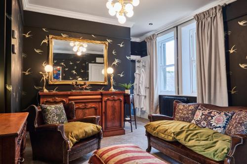a living room with a couch and a mirror at The Snug @ Clarence in Derry Londonderry
