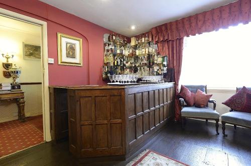 a bar in a room with a red wall at Meryan House Hotel in Taunton