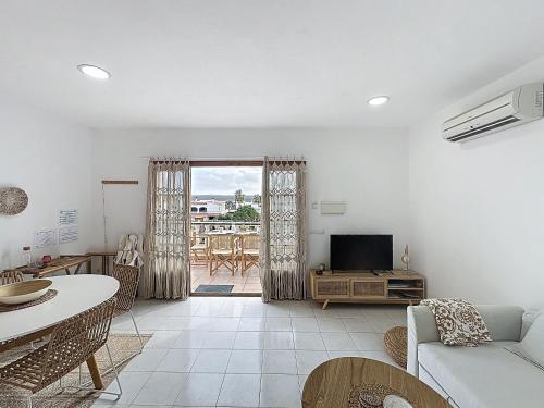 a living room with a couch and a tv at Apartamento con piscina SS20 in Fornells