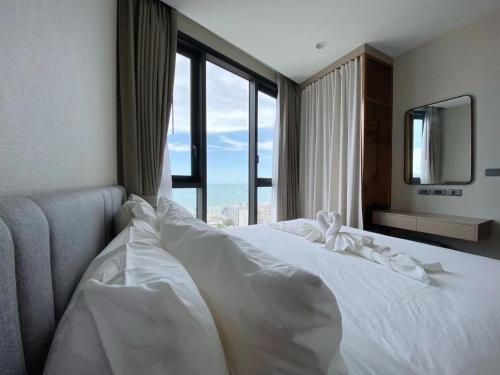 a white bed in a room with a large window at EDGE Central PATTAYA SKY in Pattaya