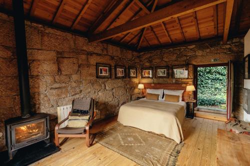 a bedroom with a bed and a fireplace at Casa Agricola da Levada Eco Village in Vila Real