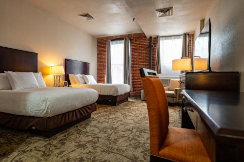 a hotel room with two beds and a desk at The Inn Down Town in Erie