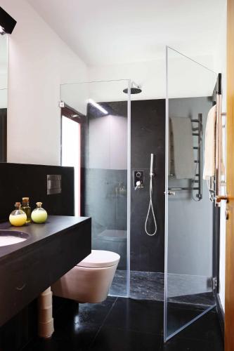 a bathroom with a toilet and a glass shower at Casa Agricola da Levada Eco Village in Vila Real