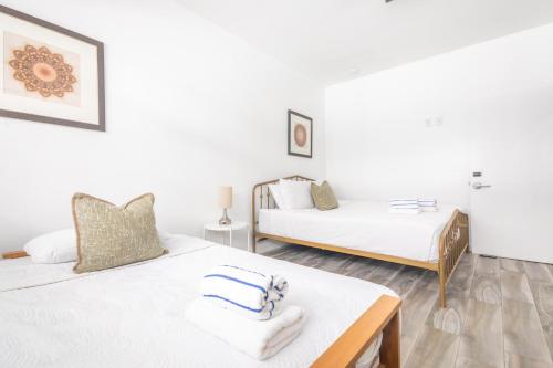two beds in a room with white walls at Boutique Apartments Flamingo in Miami Beach