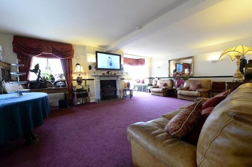 a living room with a couch and a television at Meryan House Hotel in Taunton