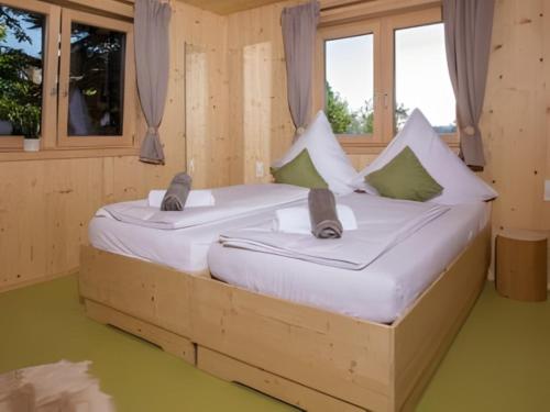 two beds in a wooden room with windows at Saunaloft Schwarzwald - privater 45qm Saunabereich - großzügige Räume mit viel Ruhe in Gemeinde Aichhalden