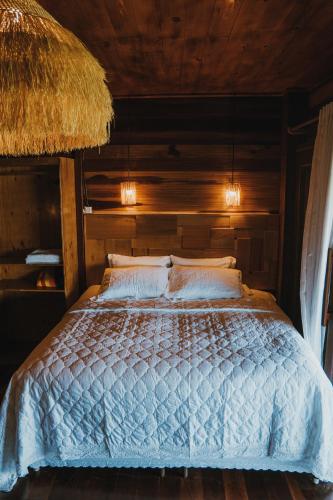 a bedroom with a bed with a wooden ceiling at Áurea chalés in Tutóia