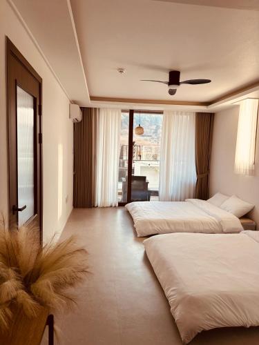 a bedroom with two beds and a ceiling fan at Radiance Stay in Paengnodam