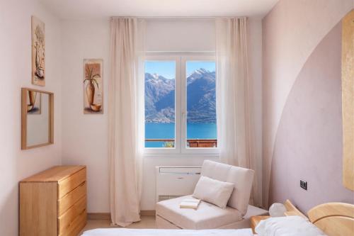 a bedroom with a window and a couch and a chair at Mont&Lac Lake View Apartment in Limone in Limone sul Garda