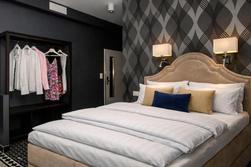 a bedroom with a large white bed with blue pillows at Amber Suite Szczecin hotel na Starym Mieście Adults Only in Szczecin