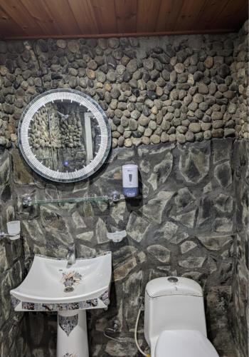 a stone bathroom with a sink and a toilet at Comfort Hotel & Huts in Skardu