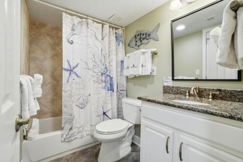 a bathroom with a toilet and a sink and a mirror at SeaSpray West 303-Gulf Front in Perdido Key